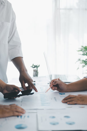 Business teamwork reviewing financial report with charts and graphs in modern office, colleagues discussing analysis, planning strategy, growth and corporate success with documents and technology.の写真素材
