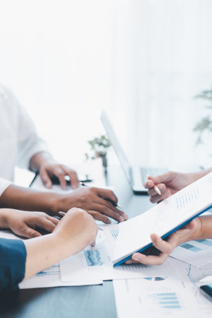 Business teamwork reviewing financial report with charts and graphs in modern office, colleagues discussing analysis, planning strategy, growth and corporate success with documents and technology.の写真素材