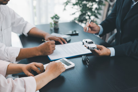 Customer signing car loan contract with dealer showing vehicle model, concept of auto finance, leasing, insurance or purchase agreement, business negotiation and financial planning. auto finance.の写真素材