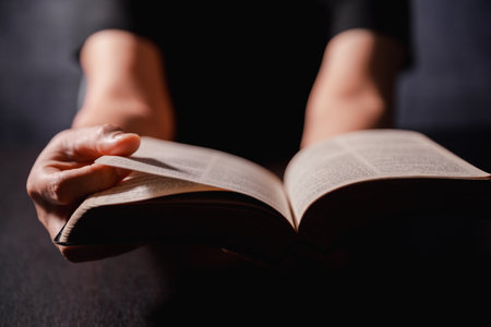 Bible in hand, christian lifts prayer in worship, holding firmly to holy concept of faith, hope and deep belief guides their spiritual life. Hands together in prayer to God along with bibleの写真素材