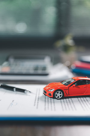 Car loan approval concept. Client finalizes purchase of vehicle by signing contract includes auto loan, insurance, credit terms, making car smart financial investment business-backed finance option.の写真素材