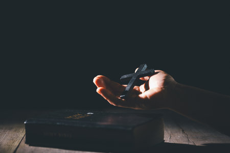 Hands clasped in prayer over the holy Bible, the faithful Christian worships God in church, holding onto hope and belief, guided by religion and a deep commitment to their religious faith.の写真素材