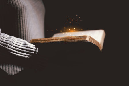 Open Bible glowing with golden light, symbolizing the Word of God, faith, prayer, hope, spiritual guidance, Christianity, holy scripture, wisdom, divine inspiration and eternal truth.の写真素材