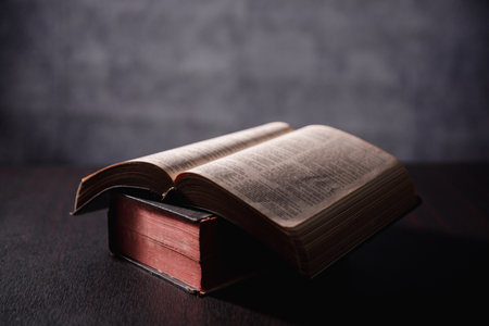 Open Bible on black background. Religion concept. a Christian sat reading an open Bible the holy...