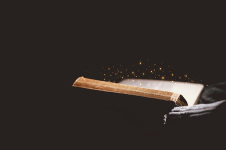 Open Bible glowing with golden light, symbolizing the Word of God, faith, prayer, hope, spiritual guidance, Christianity, holy scripture, wisdom, divine inspiration and eternal truth.の写真素材