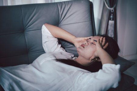 Sorrowful woman sat alone, overwhelmed by emotion, her sad and unhappy expression revealing deep despair, stress and distress left feeling depressed. sorrowful sad, despair alone, depressed stressの写真素材