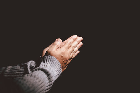 Person holding hands together in prayer gesture, symbolizing hope, faith, meditation, spirituality,...