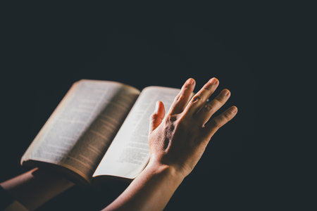 Dark silence of the church, a Christian lifts their hand in prayer to God, a symbol of worship,...