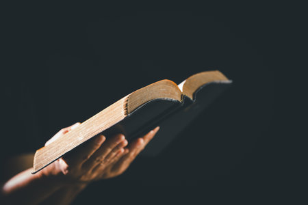 Dark silence of the church, a person lifts their hand in prayer, a symbol of worship, faith, and...