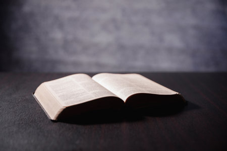 Open Bible on black background. Religion concept. a Christian sat reading an open Bible the holy...