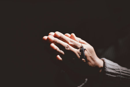 Person holding hands together in prayer gesture, symbolizing hope, faith, meditation, spirituality, trust, belief, peace, devotion, inner strength and resilience during hard times.の写真素材