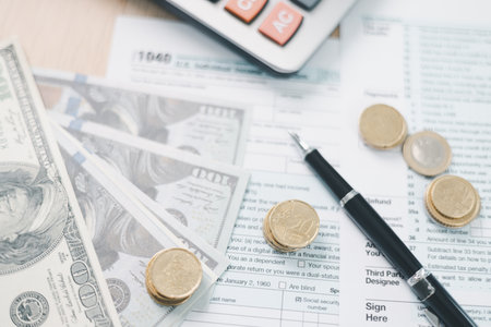 Concept of tax season and financial accounting. Stack of US dollar bills clipped on income tax...
