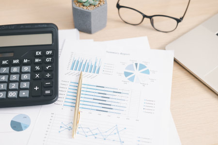 Business financial report with charts, graphs, calculator and pen on office desk, concept of accounting analysis, data management, financial planning and company performance review.の写真素材