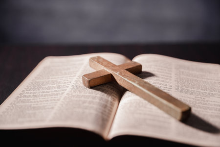 Open Bible on black background. Religion concept. a Christian sat reading an open Bible the holy book of Christianity deepening their faith in God and Jesus Christ, the foundation of their religion.の写真素材
