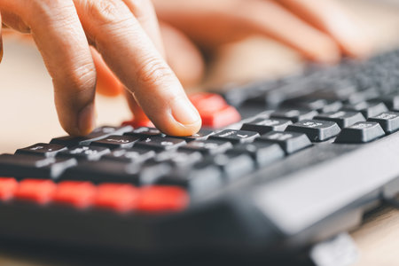 Close-up of fingers typing on computer keyboard for data entry and online work. Technology,...