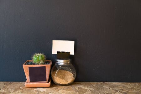 small cactus vase and a tiny brown sugar bottle for decoration with blank paper space for some text.の写真素材