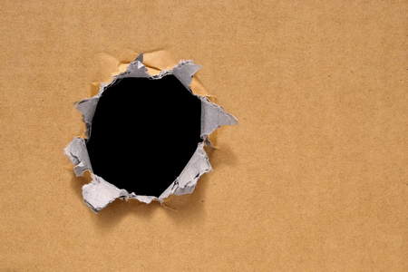 Big hole on a thick new brown cardboard. Big black hole for text, copy or every design.の写真素材