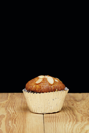 Banana cupcake, very yummy and delicious banana cake and almond toping on the wood table with free space.の写真素材