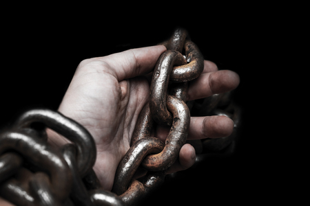 victim, slave, prosoner male hands tied by big metal chain by him self. People have no freedom concept image.の写真素材