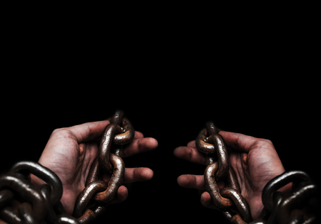 Victim, Slave, Prisoner male hands tied by big metal chain by him self. People have no freedom...