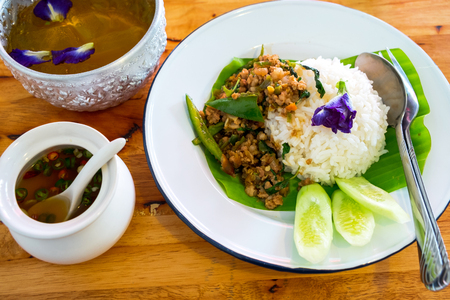 Rice topped with stir-fried pork and basil on the Wood Table, the most Poppular Menu in Thailand.の写真素材