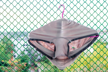 Old Underpants with a Big Hole and Tear of a Poor man Hanging on a Terrace.の写真素材