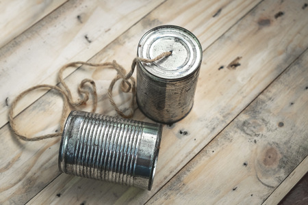 Simple Communication Device Made of Old Tin Can on Wood Background. の写真素材