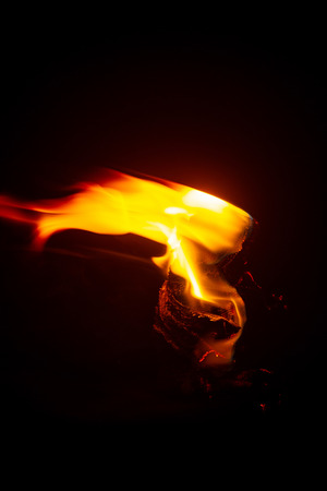 Torch Flame in the Darkness, Close up Low Key Torch with Detail of Burned Fabric.の写真素材