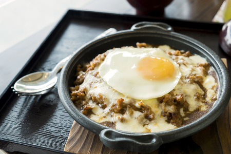 Fried Beef on Rice and Cheese with Fried egg in the Resturant.
