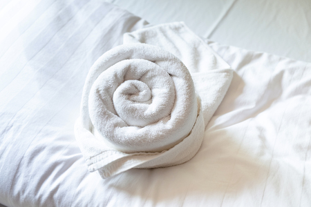 Rose Shape Towel decoration on the Clean White Bed.の写真素材