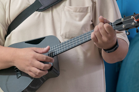 Professional Musician Playing Modern Ukulele Guitar in the Outdoor Mini Concert.