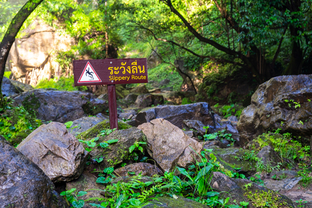 Slippery Route Warning Sign in the National Park Waterfall.の写真素材