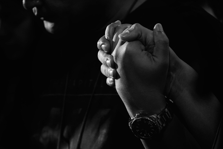 Man Friend Holding Hands and Praying Together. Vintage Style and Gain Added.の写真素材