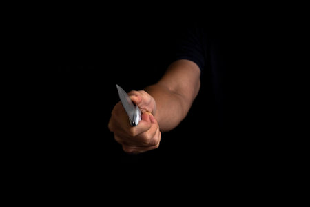 Adult Man Holding Sharp Knife in the Shadow. Concept Picture of Murderer, Killer, Assasin, Robber or Theft.の写真素材