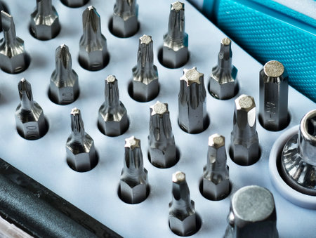 Various small screwdriver bits in different shapes and sizes, captured in a selectively focused...