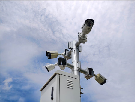 Multiple security cameras installed to ensure safety, set against a beautiful sky backgroundの写真素材