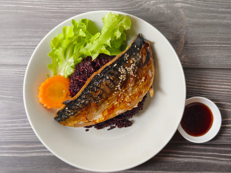 Delicious steamed mackerel with soy sauce on black rice, topped with sesame. Healthy homemade Asian food concept.の写真素材