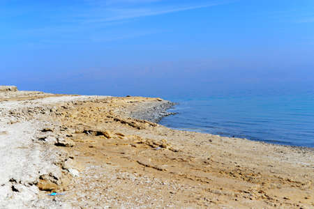 Dead Sea coastline with white salt beach in Ein Bokek, Israel. Famous Middle East health landmark. White mineral salt beach at Dead sea, Israel. Beautiful turquoise water coastline of the Dead Seaの写真素材