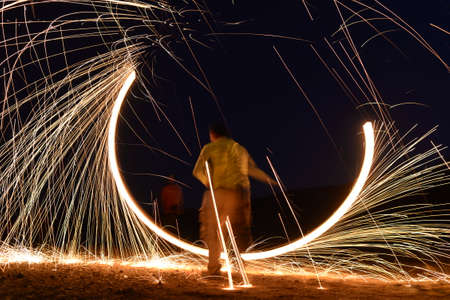 Iron wool circle drawing light fireworks. Burning Steel Wool spinning, Trajectories of burning...
