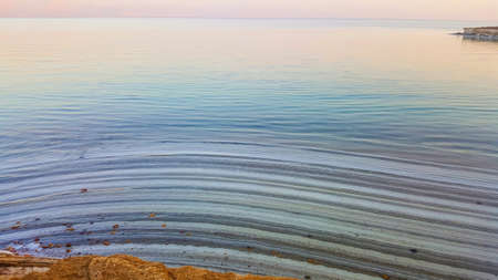 View of Dead Sea coastline. Salt crystals at sunset. Texture of Dead sea. Salty sea shore. Landscape Dead Sea coastline with natural relief channels in summer day,  failures of the soilの写真素材