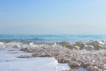 Close up of sand and sea waves on the beach with copy spaceの写真素材
