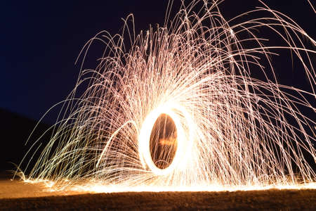 Sparks from spinning steel wool at night, closeup viewの写真素材