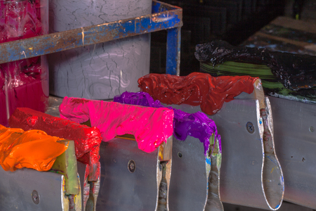ink on rubber handle hang on place above plastisol ink in cans ready for print tee shirtの写真素材