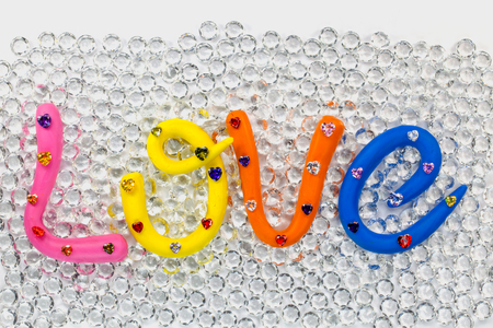 L in pink color O in yellow color V in orange and E in blue color. the word love in colorful alphabet decorate with diamonds for valentine day.の写真素材