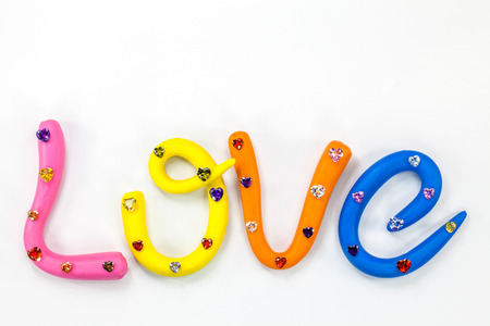 L in pink color O in yellow color V in orange and E in blue color. the word love in colorful alphabet decorate with diamonds for valentine day.の写真素材
