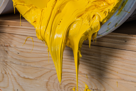 yellow color of plastisol ink flowed out of the barrel. plastisol ink is specially for print on tee shirts and any fabric. the ink useful in tee shirt factory garment and industry for exportの写真素材