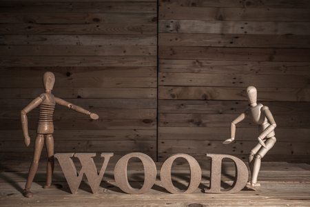 wooden puppets with wood word on wood table in wood sceneの写真素材