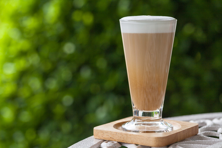 hot Latte coffee on white table in the gardenの写真素材