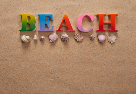 top view of beach written in colorful letters decorate with shellfish on the beach with copy spaceの写真素材