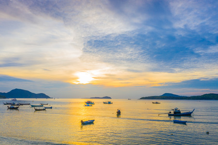 sunrise at Rawai beach Phuket Thailand. fishing boat in Rawai sea with cloudy skyの写真素材